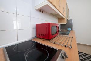 um micro-ondas vermelho sentado em cima de um balcão de cozinha em Hauzify I Apartamento Celeste em San Sebastián de la Gomera