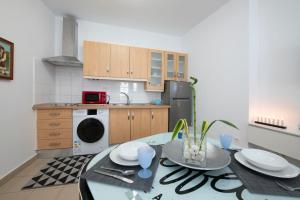 uma cozinha com uma mesa com pratos e um lavatório em Hauzify I Apartamento Celeste em San Sebastián de la Gomera