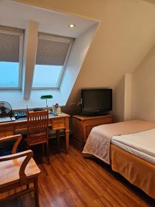 a bedroom with two beds and a desk and a tv at Best Western Hotel Apollo in Oulu