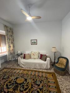 uma sala de estar com um sofá e uma cadeira em Las Cocheras del Marqués em Cehegín