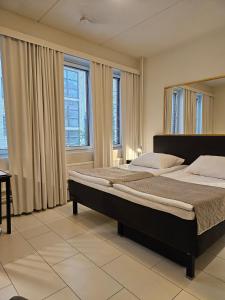 een slaapkamer met een groot bed voor de ramen bij Best Western Hotel Apollo in Oulu