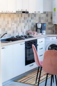 a kitchen with a stove and a washing machine at Turquoise IuliusMall Apartament apartament 2 camere in Iaşi