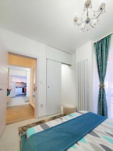 a bedroom with a blue bed and a chandelier at Turquoise IuliusMall Apartament apartament 2 camere in Iaşi