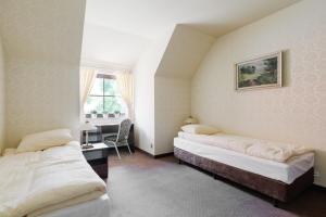 ズギェシにあるHotel Folwarkのベッド2台と机と窓のある寝室 +73枚の写真