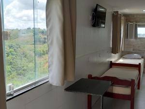 a small room with a table and a window at Apartamentos Mobiliados in Aldeia