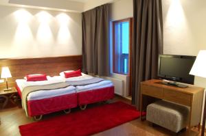 サーリセルカにあるサンタズ ホテル トゥントゥリのベッドとテレビが備わるホテルルームです。