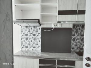 a kitchen with white cabinets and a stove top oven at Apartemen Skylounge Makassar in Manda