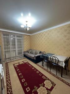 a bedroom with a bed and a table and chairs at Уютная квартира комфорт класса111 in Astana