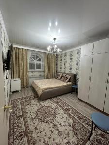 a bedroom with a bed and a rug at Уютная квартира комфорт класса111 in Astana