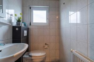 a bathroom with a sink and a toilet and a window at Ferienhaus-Ivory-in-Binz in Binz +7 photos