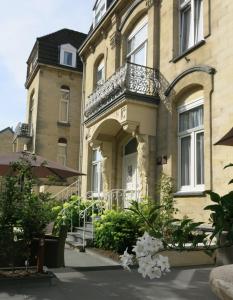a building with a balcony and flowers in front of it at Appartementen Valkenburg in Valkenburg