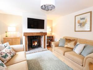a living room with two couches and a fireplace at Well Cottage in Norwich