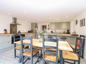 a kitchen and dining room with a wooden table and chairs at Well Cottage in Norwich