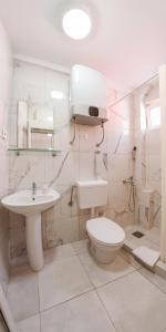 La salle de bains blanche est pourvue de toilettes et d'un lavabo. dans l'établissement Villa MD, à Budva