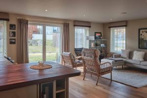 un soggiorno con tavolo, sedie e divano di The Steadings, Aviemore Luxury 5 star rated 3 Bed with home cinema garden and parking ad Aviemore