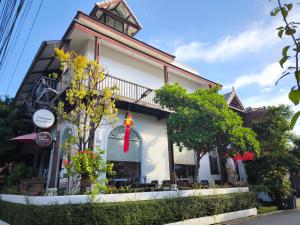 a white building with a red ribbon on it at Ratchiangsaen Flora House in Chiang Mai
