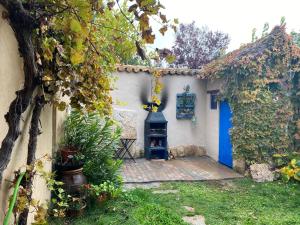 um jardim com uma porta azul e uma lareira em Casa rural De Añil - Jardín privado, wifi, netflix y aire acondicionado em Velliza