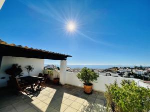 a patio with a table and a view of the ocean at Blue jasmine in Cala del Moral