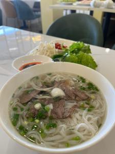 a bowl of soup with meat and noodles on a table at Thanh Thanh Hotel in Da Lat