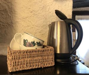 a tea kettle and a basket on a table at Sleep'n and go Country House in Menaggio