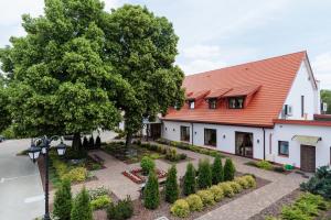 una casa con un jardín delante de ella en Hotel Folwark en Zgierz