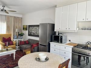 a kitchen with a table and a living room at Somerset West Garden Apartments 2 in Somerset West