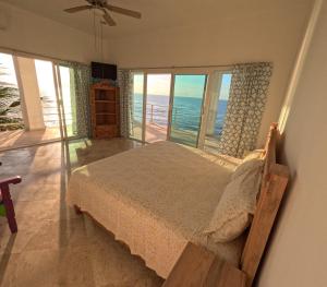 1 dormitorio con 1 cama y vistas al océano en Hotel Luz de Mar ' right on the beach, en Cuatunalco