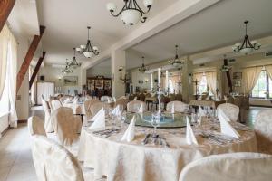 a banquet hall with white tables and chairs at Hotel Folwark in Zgierz