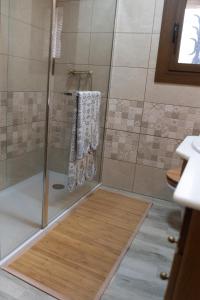 uma casa de banho com um chuveiro e toalhas brancas num piso em Masia Casa Nova de n'Illa em Montseny