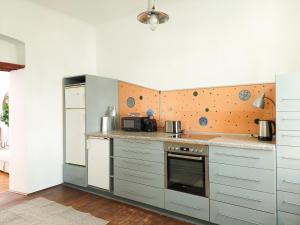 uma cozinha com armários brancos e um forno com placa de fogão em Hidden Garden - 160 m² - 1 min to City Shuttle em Viena