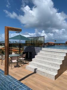 een patio met een trap, een tafel en een zwembad bij Pousada Atlantic in Porto De Galinhas