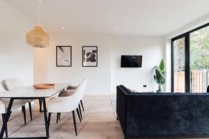 sala de estar con mesa y sofá en Modern & Bright Luxury London Apartment in Honor Oak, en Londres