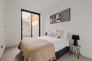 Habitación blanca con cama y ventana en Modern & Bright Luxury London Apartment in Honor Oak, en Londres