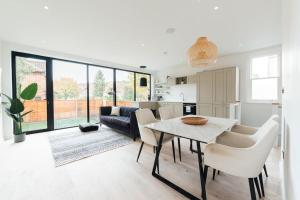 cocina y sala de estar con mesa y sillas en Modern & Bright Luxury London Apartment in Honor Oak, en Londres