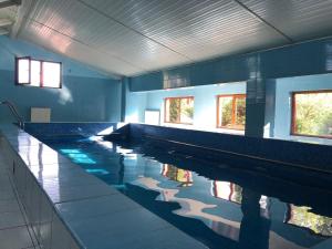 a large swimming pool with water in a room at Pensiunea Soreanca in Costeşti