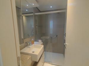 a white bathroom with a sink and a shower at Jade Hotel BLUE Tree Brasília Flat Particular wi-fi e garagem grátis sem café in Brasilia