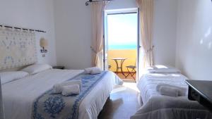 a bedroom with two beds and a view of the ocean at Hotel Castello in Golfo Aranci