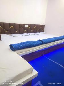 a pair of beds in a room with blue floors at Hotel PRABHU PALACE in Ujjain