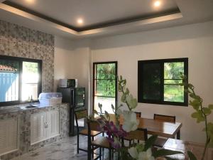 a living room with a table and a kitchen at Villa Cattleya by orchids pool villas in Ko Lanta