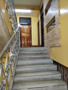 a set of stairs leading up to a wooden door at Balaji Guest House in Shillong