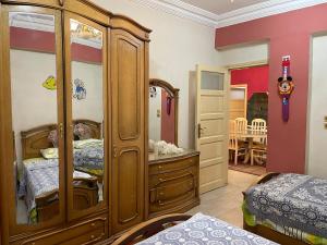 a bedroom with a large wooden cabinet in a room at Dr milad shokralla multiple central flats in Luxor