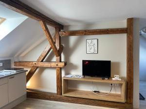 uma sala de estar com uma televisão numa mesa de madeira em VATUS Apartmanház Vác em Vác