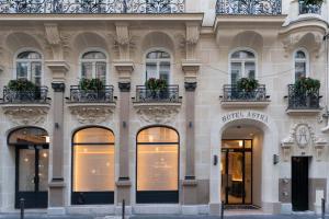 una fachada de un edificio con ventanas y plantas en Hotel Astra Opera - Astotel en París