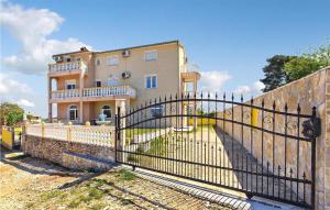 a fence in front of a house with a building at Lovely Apartment In Pula With Kitchen in Pula
