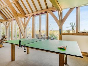 een tafeltennistafel in een kamer met ramen bij Wylye Croft in Upwey