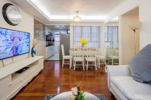 ein Wohnzimmer mit einem weißen Sofa und einem Esszimmer in der Unterkunft Tsim ShaTsui Luxury 3bedroom Apartment near MTR！ in Hongkong