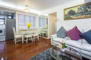 ein Wohnzimmer mit einem weißen Sofa und einem Esszimmer in der Unterkunft Tsim ShaTsui Luxury 3bedroom Apartment near MTR！ in Hongkong
