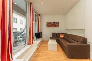 a living room with a couch and a tv at Appartements Tamino by Schladming-Appartements in Schladming