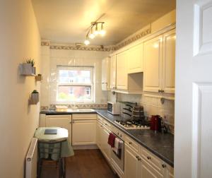 a kitchen with white cabinets and a sink at Doncaster - Town Centre - 2 Bedrooms & Sofa Bed - Very Quiet Location in Doncaster