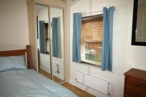 a bedroom with a bed and a window with blue curtains at Doncaster - Town Centre - 2 Bedrooms & Sofa Bed - Very Quiet Location in Doncaster